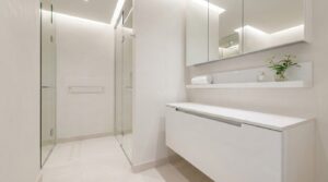 Sleek minimalist bathroom showcasing hidden storage cabinets and floating shelves.